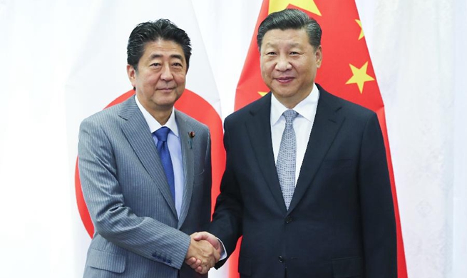 Xi, Abe meet on further improving China-Japan ties